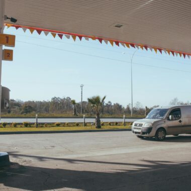 Car near gas station against cloudless sky